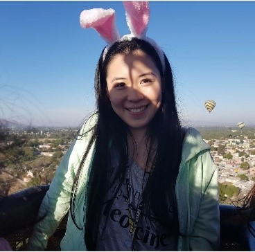 la imagen puede contener a una mujer, de cabello negro oscuro posando de pie y sonriente.  